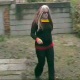 A woman with multi-colored hair takes a huge shit while squatting in her own back yard.